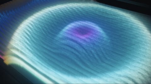 Recherches préliminaires : une nappe de lumière bleu pâle ondule, avec une tache violette en son centre